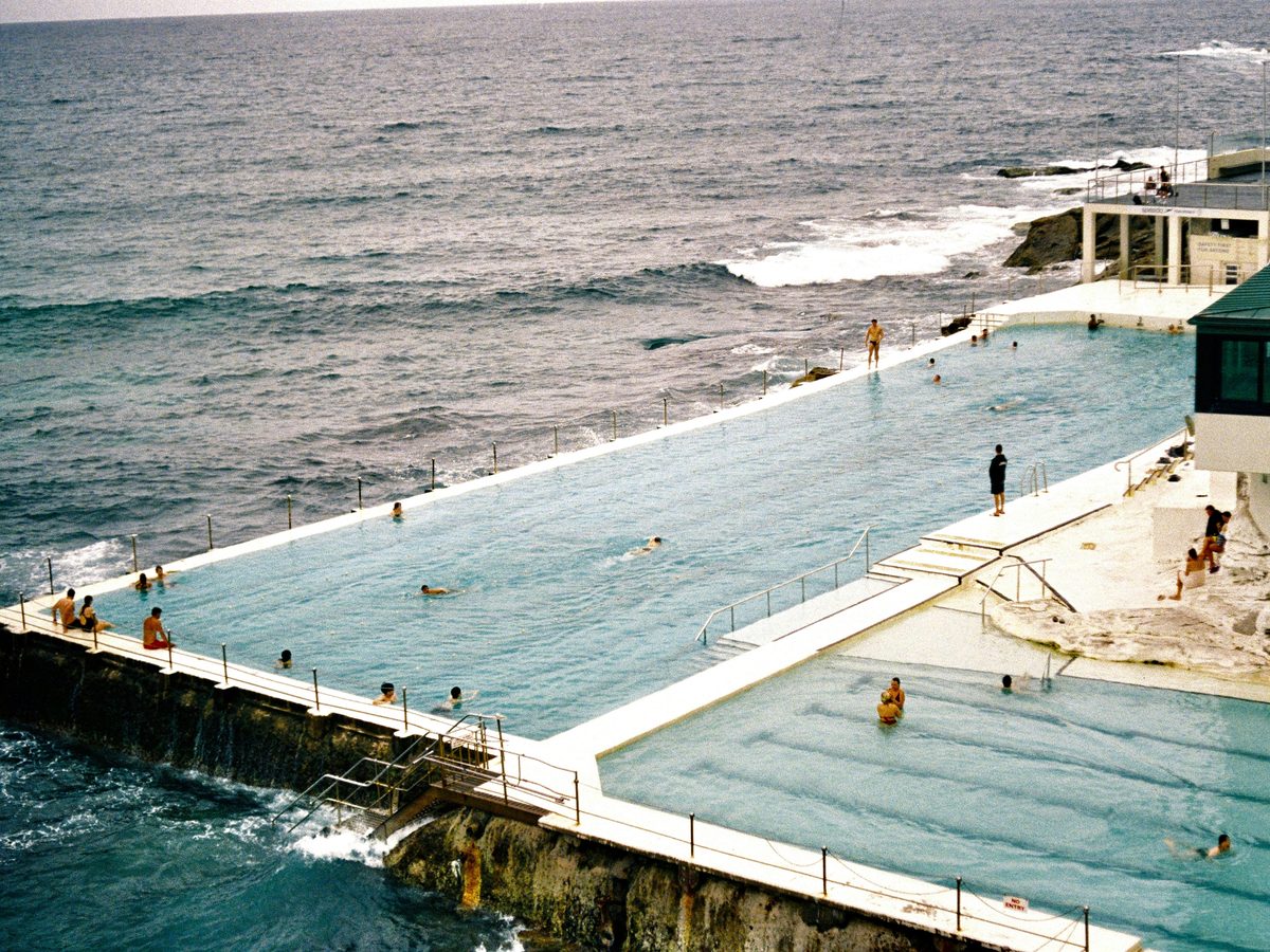 Ocean pool with swimmers beside the surf